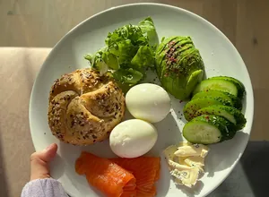 Low-carb plate with eggs, salmon, avocado and greens