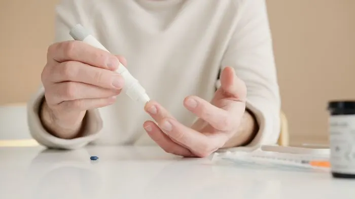 Person pricking a finger to check blood sugar