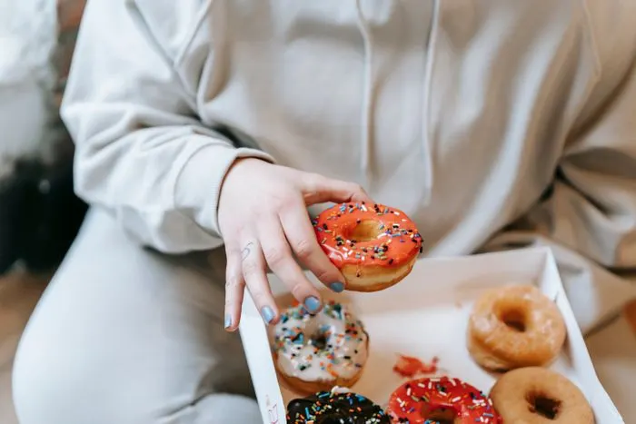 Hand reaching for a donut from a box
