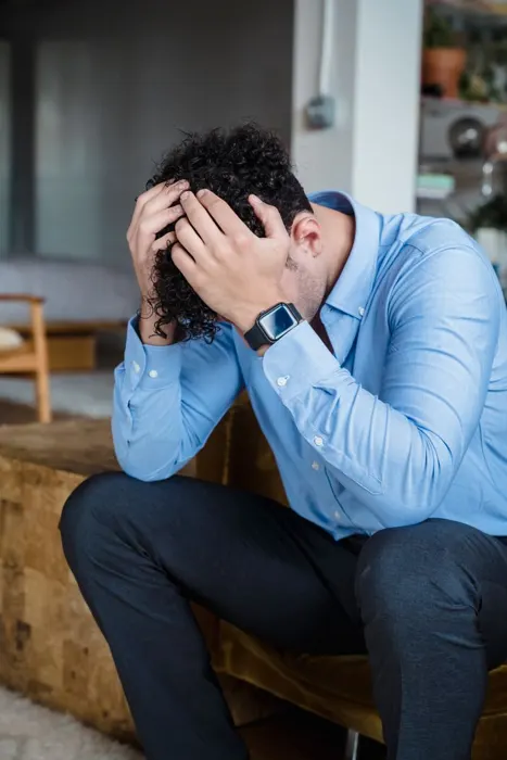 Worried man sitting with his head in his hands